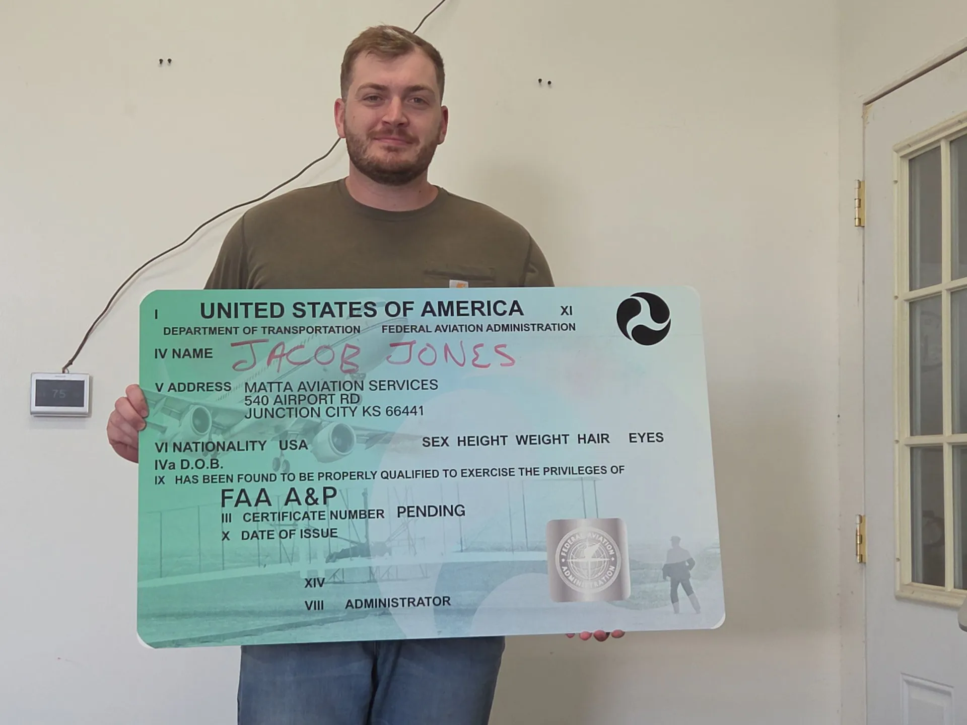 Student holding an FAA A&P certificate
